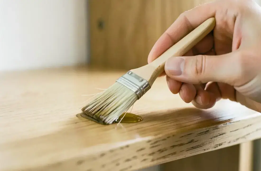Hand applying natural oil to a solid oak countertop with a folded microfibre cloth